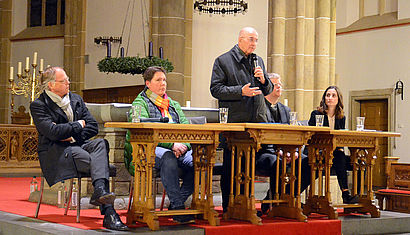 Generalvikar Klaus Winterkamp, Tanja Schalkamp (Vorsitzende des Pfarreirates), Bischof Felix Genn, Pfarrer Martin Klüsener und Moderatorin Lena Zils sitzen an einem Tisch im Altarraum der St. Margareta-Kirche Wadersloh