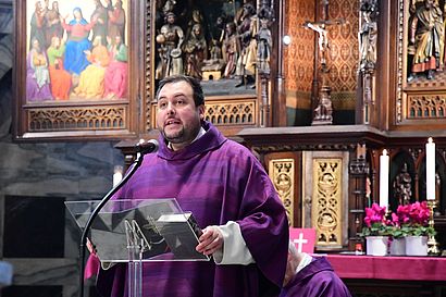 Ein Priester steht in einer Kirche.