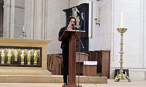 Herta Müller steht vor dem Altar des St.-Paulus-Doms an einem Stehpult und spricht in ein Mikrofon.