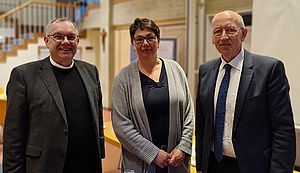 Christoph Hegge, Stephanie Heckenkamp-Grohs und Ulrich Hörsting stehen in einem Tagungsraum vor einem Flip-Chart.