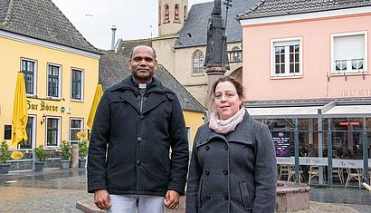 Ein Mann und eine Frau stehen nebeneinander auf einem Marktplatz.