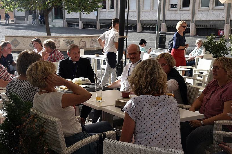 Weihbischof Wilfried Theising und Clemens Lübbers mit einigen Sängerinnen im Straßencafé