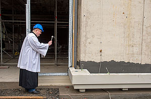 Schulseelsorger Daniel Mittelstaedt segnet den Grundstein vor dem Neubau des Kardinal-von-Galen-Gymnasiums.