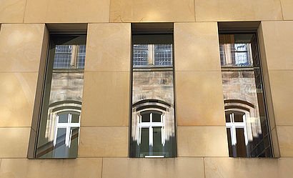 Gebäude der Hauptabteilung Seelsorge-Personal in Münster im Spiegel der Fenster der Diözesanbibliothek.