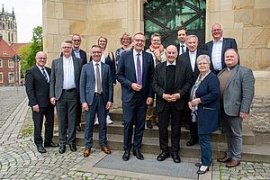 Die Teilnehmerinnen und Teilnehmer des Gesprächs stehen vor dem Eingang des St.-Paulus-Doms.