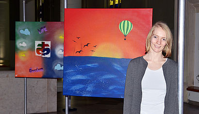 Künstlerin Patricia Kuhl steht vor den entstandenen Leinwänden.