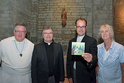 In der sogenannten Norbertzelle stehen von links Abt Albert Thomas Dölken, Propst Klaus Wittke, Pfarrer Markus Trautmann und Bärbel Stangenberg. Trautmann hält mit dem linken Arm sein Buch in die Kamera.