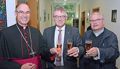 Weihbischof Rolf Lohmann, Wasserburg-Direktor Kurt Kreiten und Dechant Stefan Notz (von links) stießen mit einem Glas Sekt auf den runden Geburtstag der Wasserburg an. 