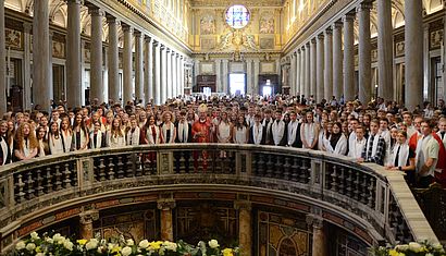 Viele Menschen stehen in einer großen Kirche.