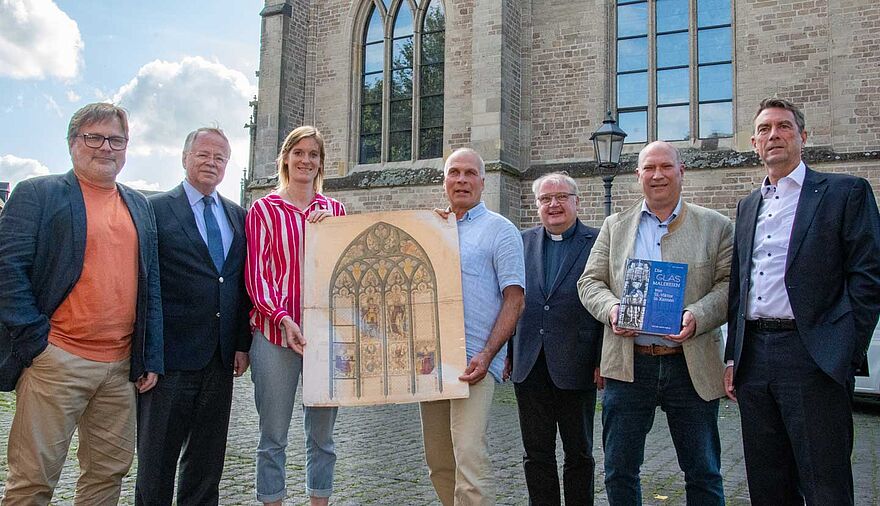 Mehrere Personen stehen vor dem Xantener Dom.