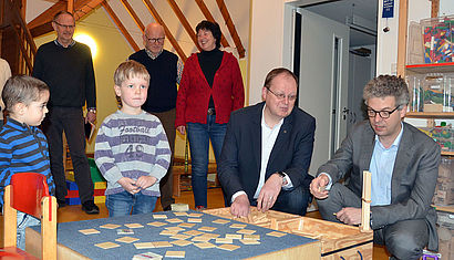 Pfarrer Jörg Hagemann und Landtagsabgeordneter Stefan Nacke im Gespräch mit Kindern. 