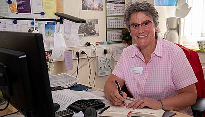 Judith Welbers sitzt in ihrem Büro an einem Schreibtisch.