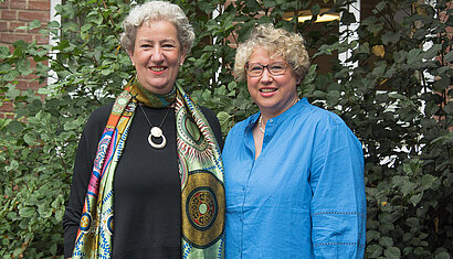 Lisa Frings und Sandra Middendorf stehen nebeneinander vor einer Hecke.