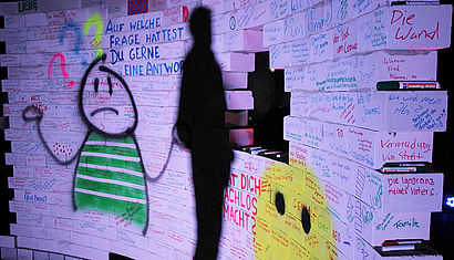 Bunt beschriftet ist die Mauer auf dem Kirchplatz der Jugendkirche.