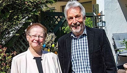 Eine Frau und ein Mann stehen nebeneinander in einem Garten.