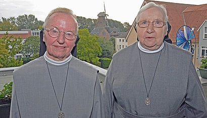 Schwester Reinilde (links) und Schwester Gisleidis stehen auf dem Balkon ihrer Wohnung. Im Hintergrund ist die Kalkarer Mühle zu sehen.