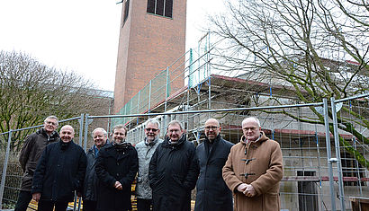 Eine Gruppe steht vor der Baustelle.