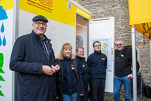 Pfarrer André Sühling, Julia Klug, Yvonne Buschkühl, Anton Vallböhmer und Karsten Berndt (von links) beim Start des mobilen Dusch- und Beratungstreffs des Arbeiter-Samariter-Bundes auf dem Überwasserkirchplatz in Münster.