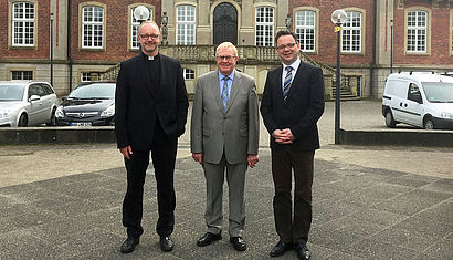 Dr. Jochen Reidegeld, Reinhold Sendker und Dr. Oliver Niedostadek stehen vor der Loburg.