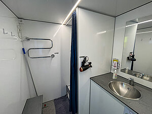 Das Foto zeigt die Duschkabine samt Waschbecken und Toilette.