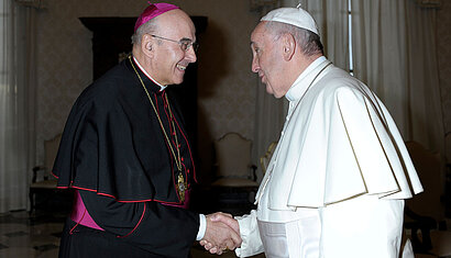 Bischof Dr. felix Genn und Papst Franziskus schütteln sich die Hände.