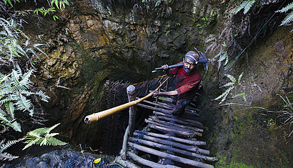 Ein indischer Bergarbeiter klettert aus einem Kohleschacht.