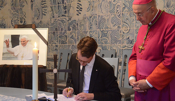 Ministerpräsident Hendrik Wüst trägt sich ins Kondolenzbuch für Papst em. benedikt XVI. ein.