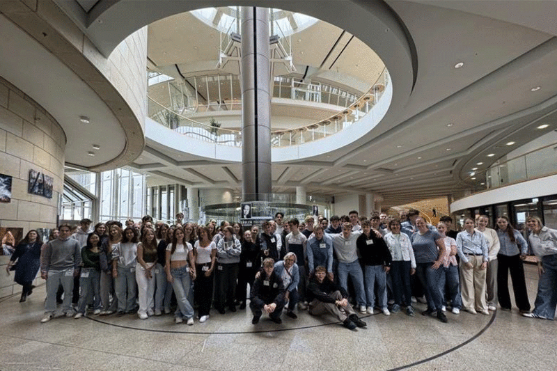 Eine große Gruppe von Schülerinnen und Schüler steht in einer großen Halle des Landtages.
