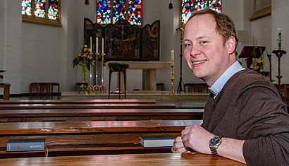 Ein Mann sitzt in einer Kirchenbank