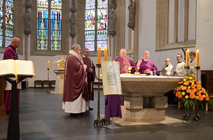 Drei Priester und ein Diakon stehen um den Altar in Beckum St. Stephanus herum.