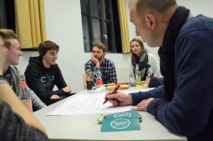 Jungen Menschen sitzen am Tisch und schreiben ihre Ideen auf. Jungen Menschen sitzen am Tisch und schreiben ihre Ideen auf.