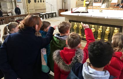 Kinder stehen vor den Apostelleuchtern im Altar des St.-Paulus-Doms.