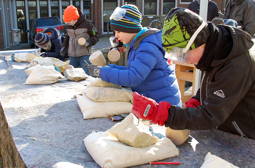 Die Kommunionkinder aus Oelde werkeln an ihren Steinarbeiten.