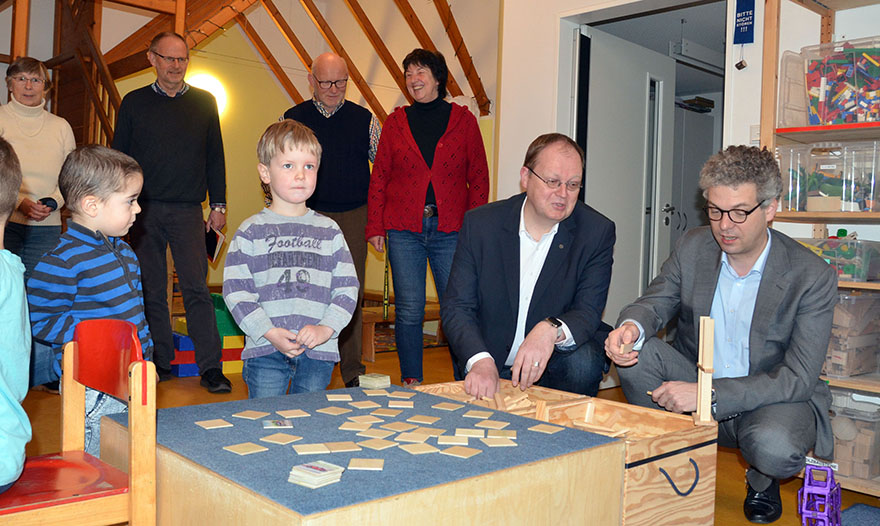 Pfarrer Jörg Hagemann und Landtagsabgeordneter Stefan Nacke im Gespräch mit Kindern. 