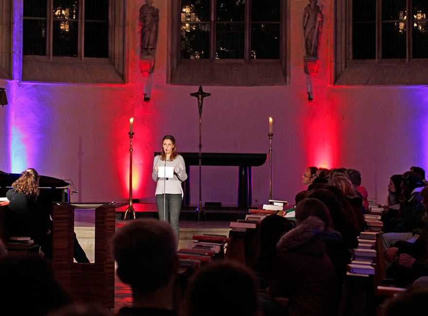 Eine junge Frau steht in der Kirche und predigt.