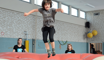 Ein Kind hüpft froh auf einem Luftkissen