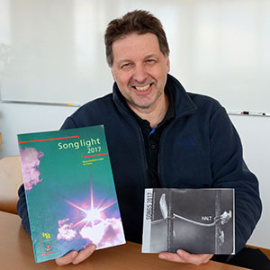 Daniel Franken zeigt zwei Liederbücher.