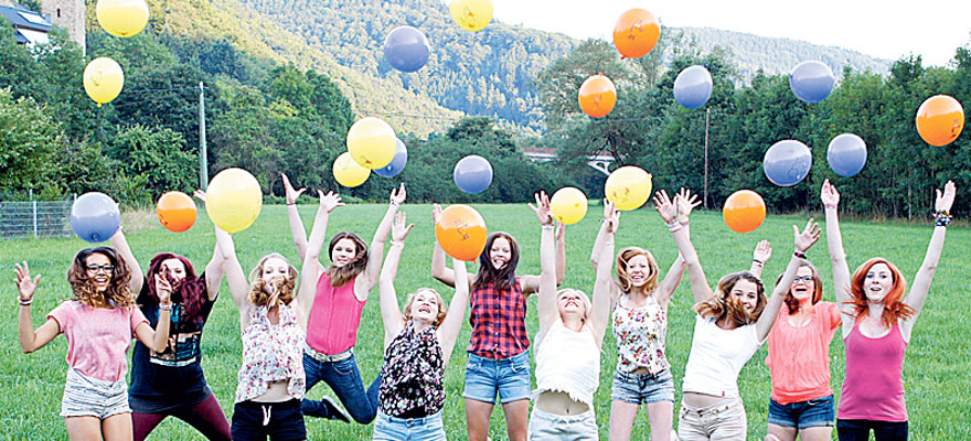 Vor Freude hochspringende Mädchen und junge Frauen.