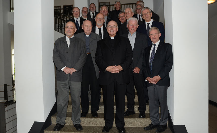 Bischof Genn und die 15 Jubilare stellten sich im Treppenhaus für ein Gruppenfoto auf.
