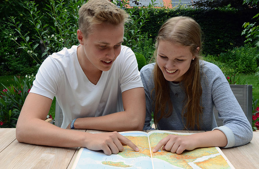 Ole Middendorf und Noemi Everding schauen auf ein Afrikakarte.