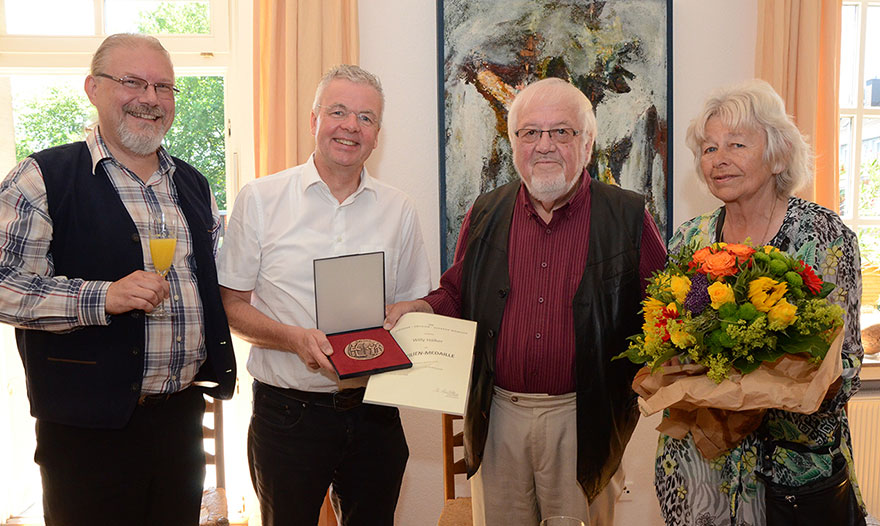 Kantor Maximilian Kramer und Pfarrdechant Johannes Arntz überraschten Willy und Waltraud Hälker (von links) mit der Cäcilienmedaille.