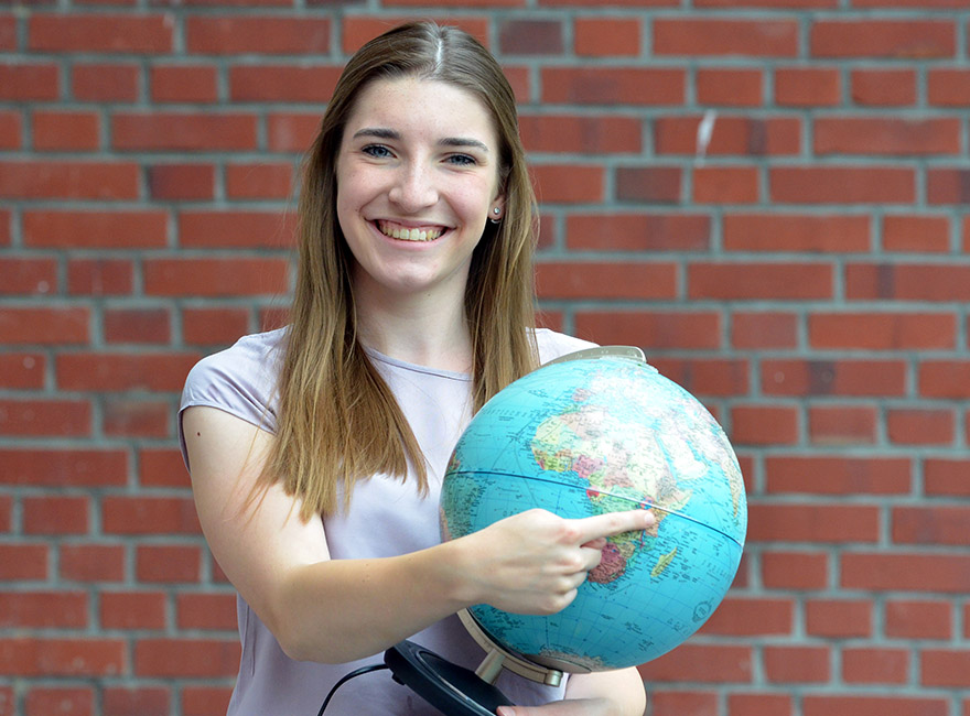Hannah Tertilt hält einen Globus in der Hand. 