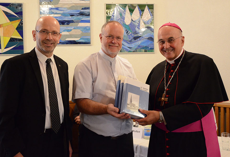 Pfarrer Clemens Kreiss und Autor Wilfried Heß überreichten Bischof Dr. Felix Genn (von links) das dreibändige Werk zur Geschichte der St.-Marien-Kirche in Lünen.