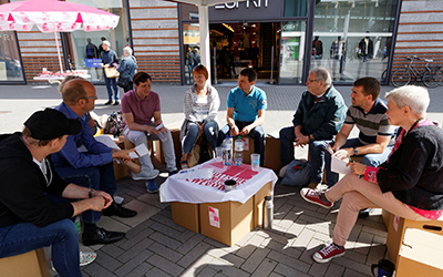 KAb-Mitglieder sitzen in einer Diskussionsrunde in der Innenstadt.