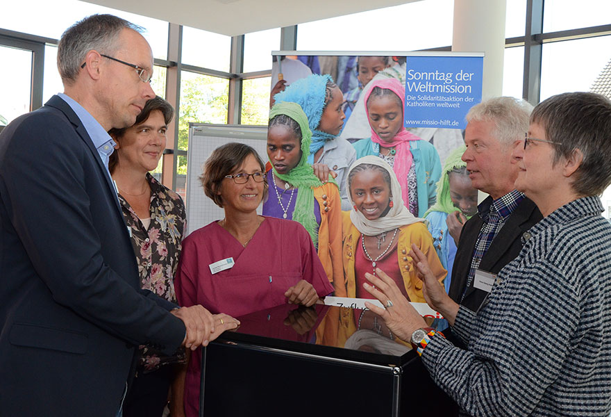 Schulleiter Andreas Holtmann, Dr. phil. Anneliese Tometten-Iseke, Leiterin der Hebammenschule, Hebamme Christel Remke-Smeek, Hans Georg Hollenhorst, Referent der missio-Diözesanstelle, und Schwester Rita Schiffer (von links) stehen zusammen am Tisch und unterhalten sich.