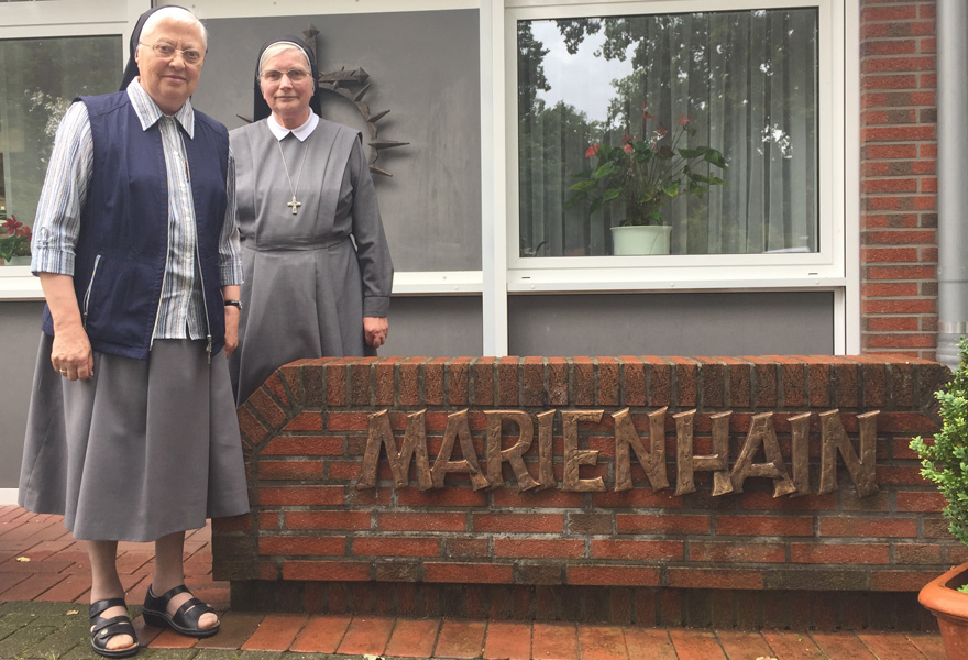 Schwester Egina (links) und Schwester Ludgera stehen neben der Aufschrift "Marienhain" am Eingang ihres Klosters.