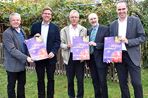 Kreisdechant Johannes Arntz, Superintendent André Ost, Kreisdechant Markus Dördelmann, Superintendent Joachim Anicker sowie Kreisdechant Christoph Rensing halten das Plakat für die Ökumenische Kirchennacht in die Kamera.