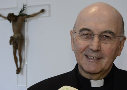 Bischof Felix Genn, lächelnd, im Hintergrund ein Wandkreuz