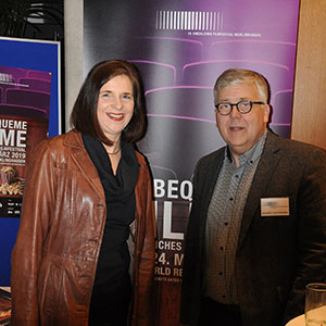 Katrin Göring-Eckardt und Joachim van Eickels stehen vor dem Plakat des Kirchlichen Filmfestivals.