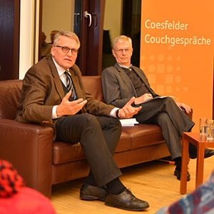 Prof. Sternberg und Eberhard Ernsting sitzen auf einer Couch und sprechen mit dem Publikum.